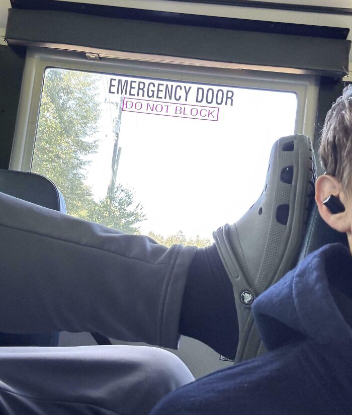 Ноги в серых кроксах упираются в аварийную дверь поезда