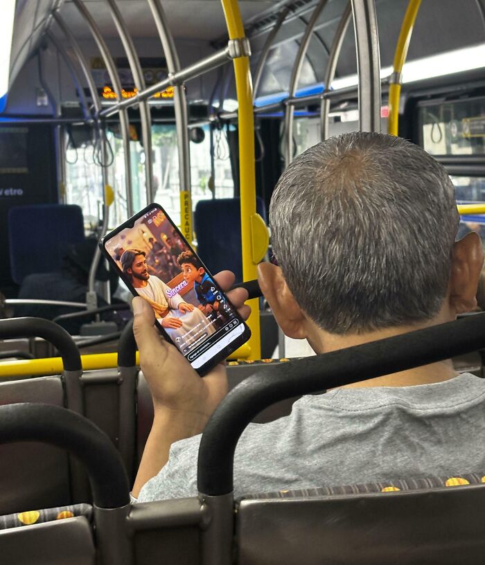 Мужчина с седыми волосами смотрит видео на смартфоне в автобусе