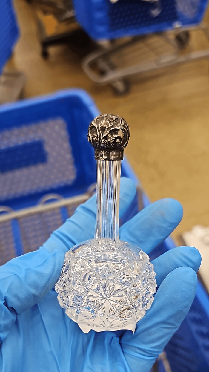 Хрустальный гранёный флакон с серебряной резной крышкой в руке в перчатке