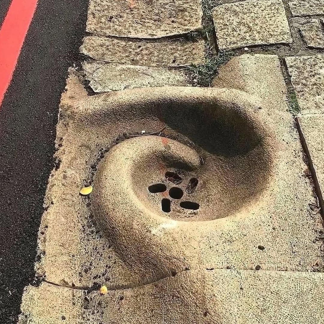 Спиралевидный водосток в форме улитки на тротуаре