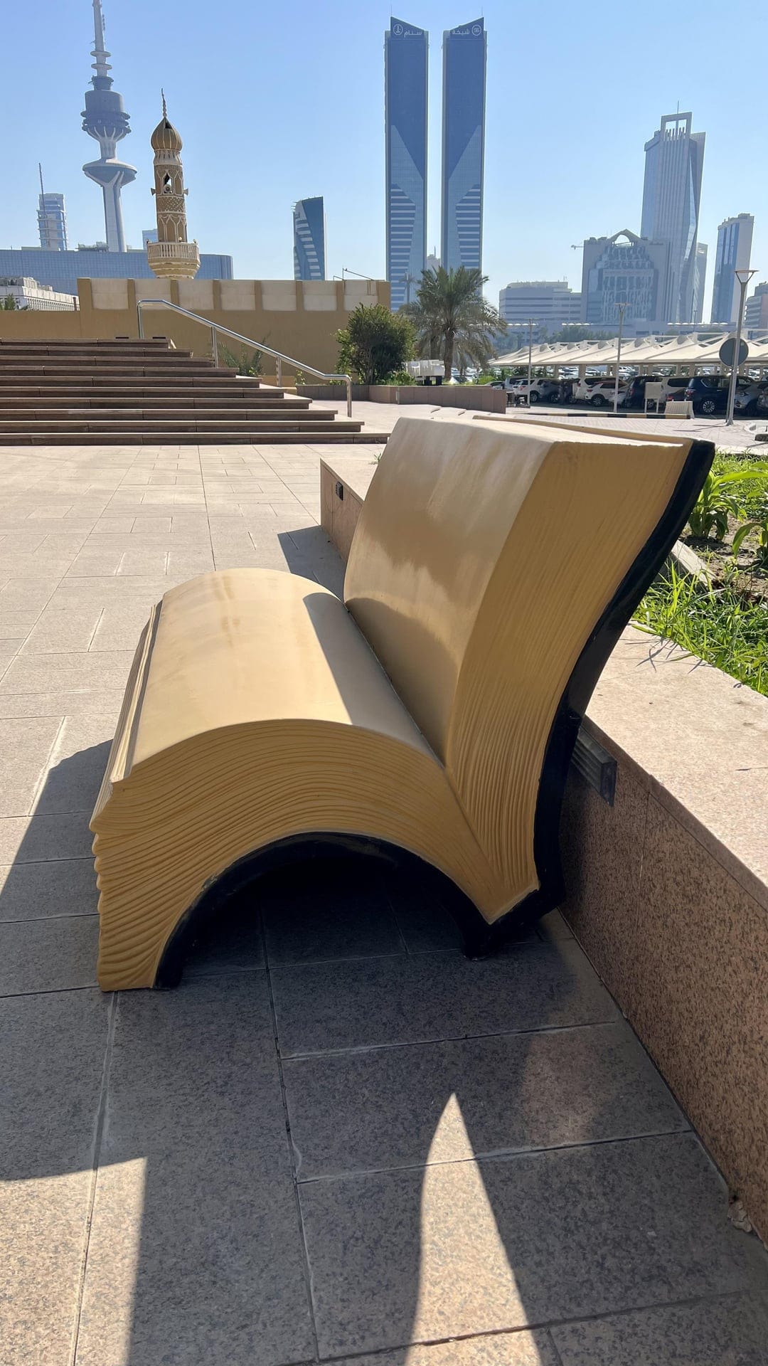 Скамейка в форме открытой книги из дерева на городской площади