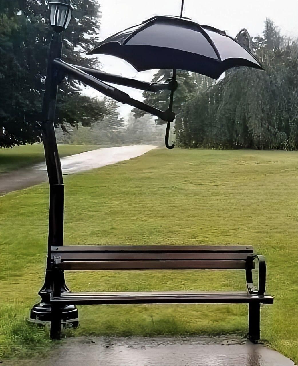 Парковая скамейка под большим чёрным зонтом-навесом в дождливый день
