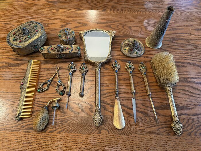 Коллекция серебряных расчёсок зеркала и шкатулок на столе