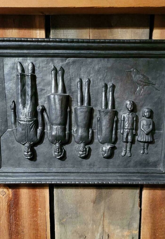 Чугунная панель с висящими фигурками детей и птицей