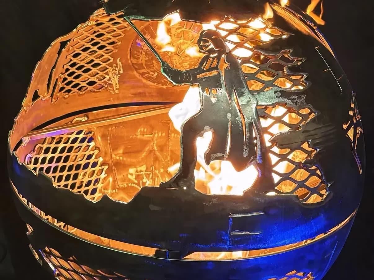 Круглая металлическая жаровня с вырезанным силуэтом Дарта Вейдера и огнём