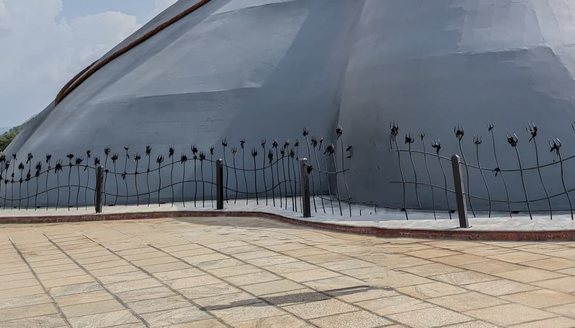 Паломники повязывают чёрную ткань на трезубцы вокруг статуи Адийоги