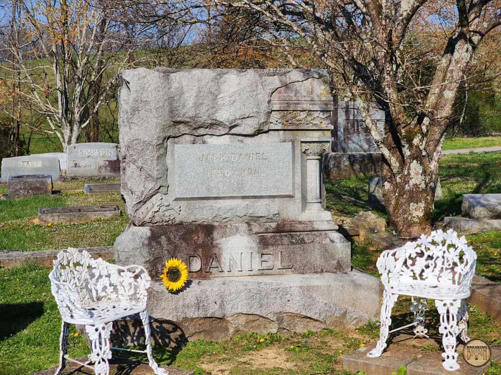Надгробный камень на могиле Джека Дэниела с выбитой датой 1850 год на фоне зеленого кладбища