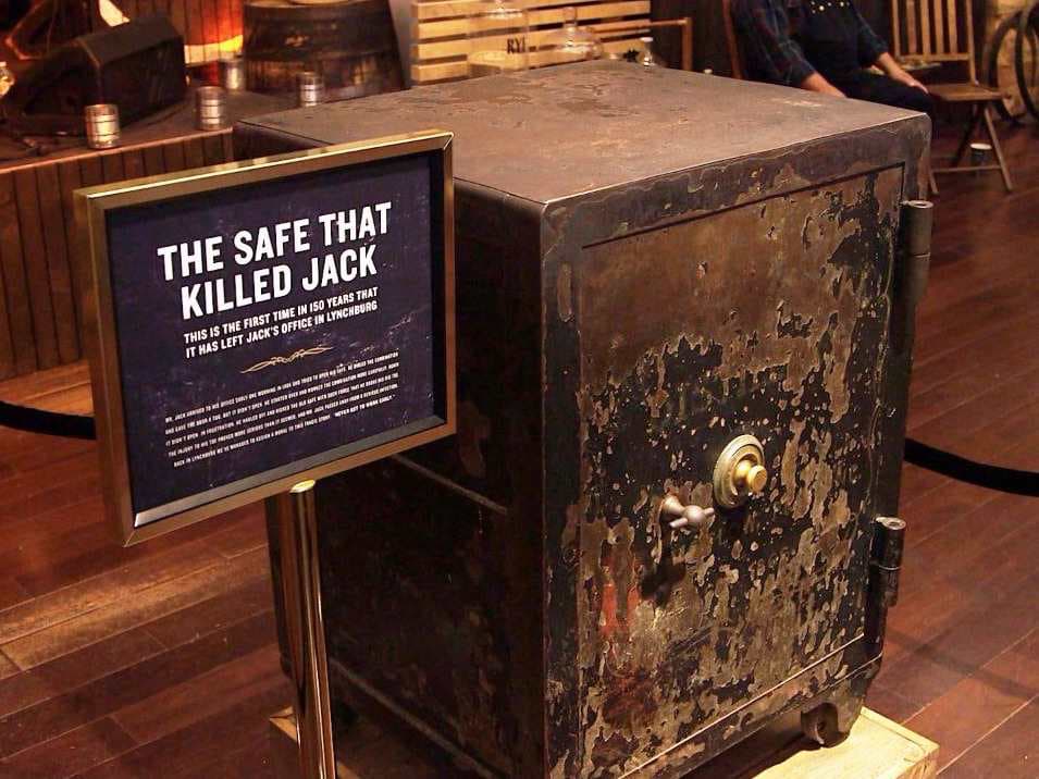 Крупный план исторического сейфа с табличкой The safe that killed Jack на фоне кирпичной стены офиса