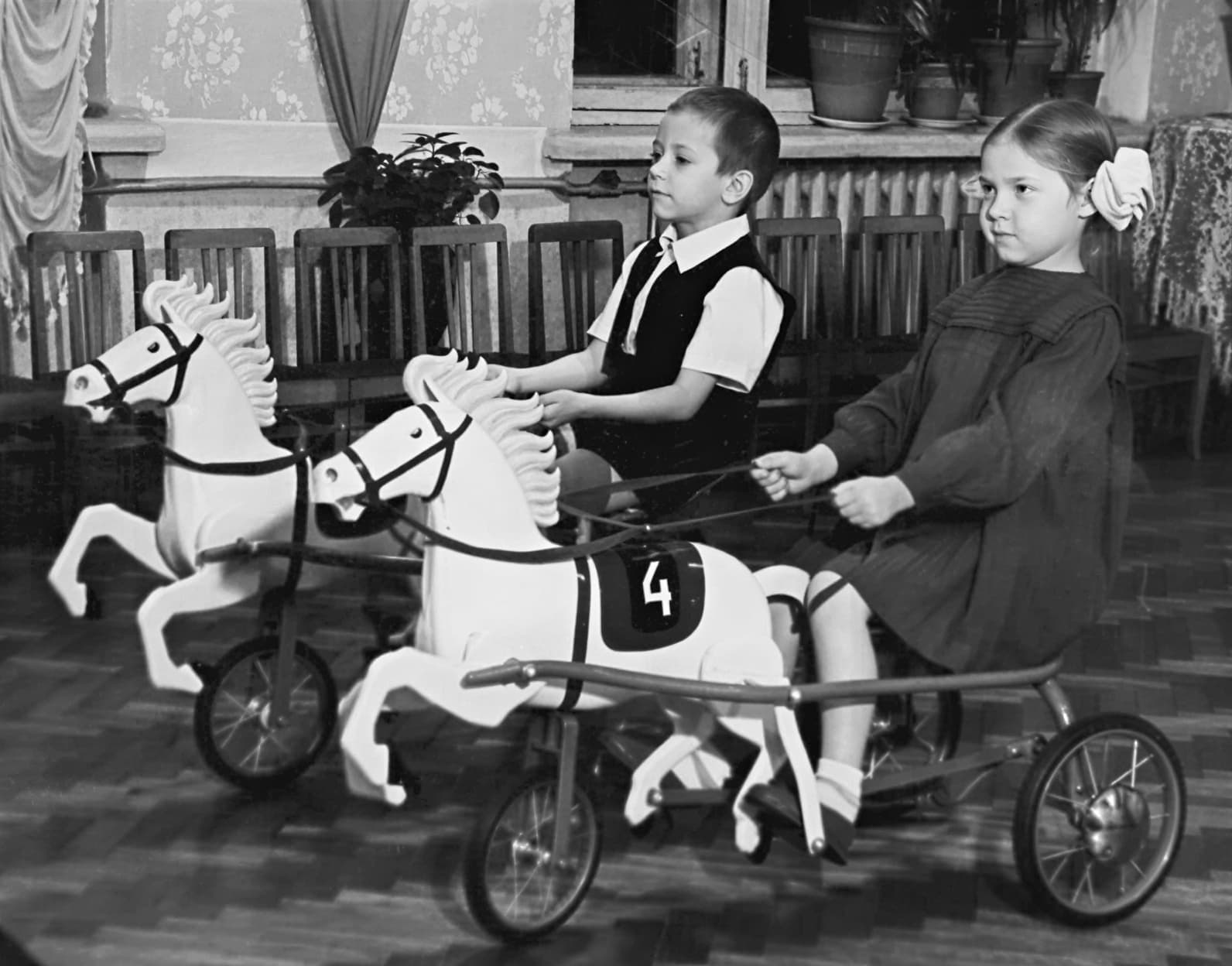 Дети на советских педальных конях в 1960-е годы. Три ребёнка верхом на игрушках с белыми гривами во дворе. Редкий кадр эксплуатации.