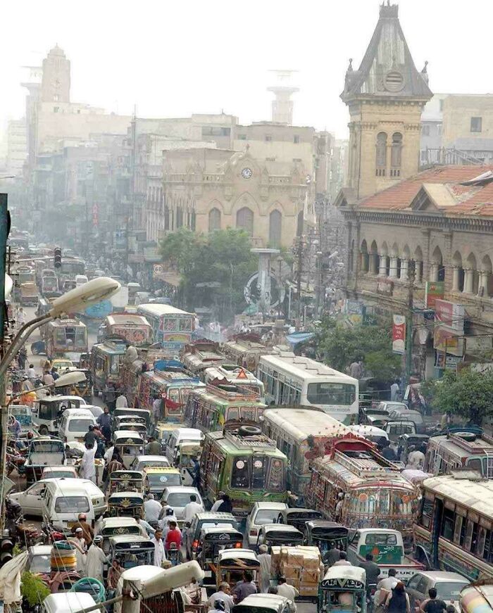 Хаотичный трафик ярких автобусов и рикш на оживленной улице