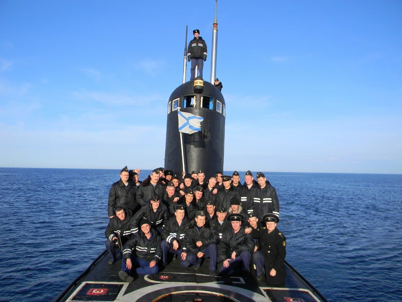 Экипаж подводной лодки в полном составе выстроился на палубе в надводном положении. Матросы в парадной форме.