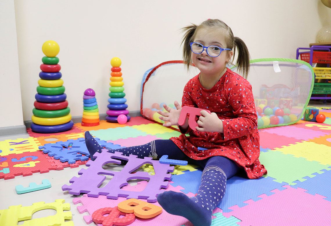 Девочка с синдромом Дауна играет