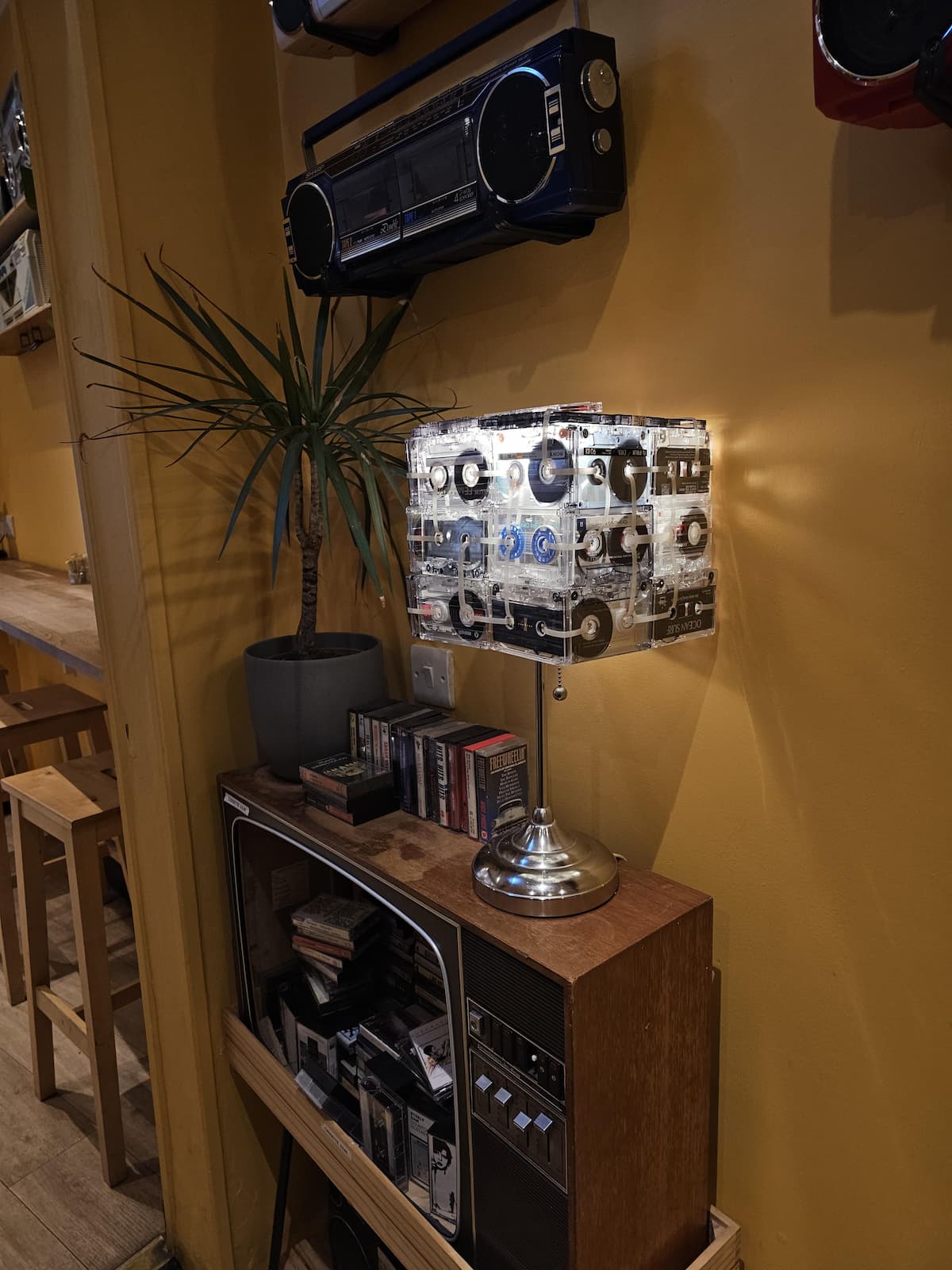 Прозрачная лампа из кассет с магнитофонными лентами на деревянном столике