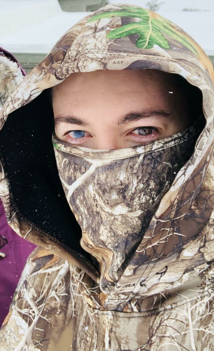 Девушка с голубыми глазами в камуфляжном капюшоне