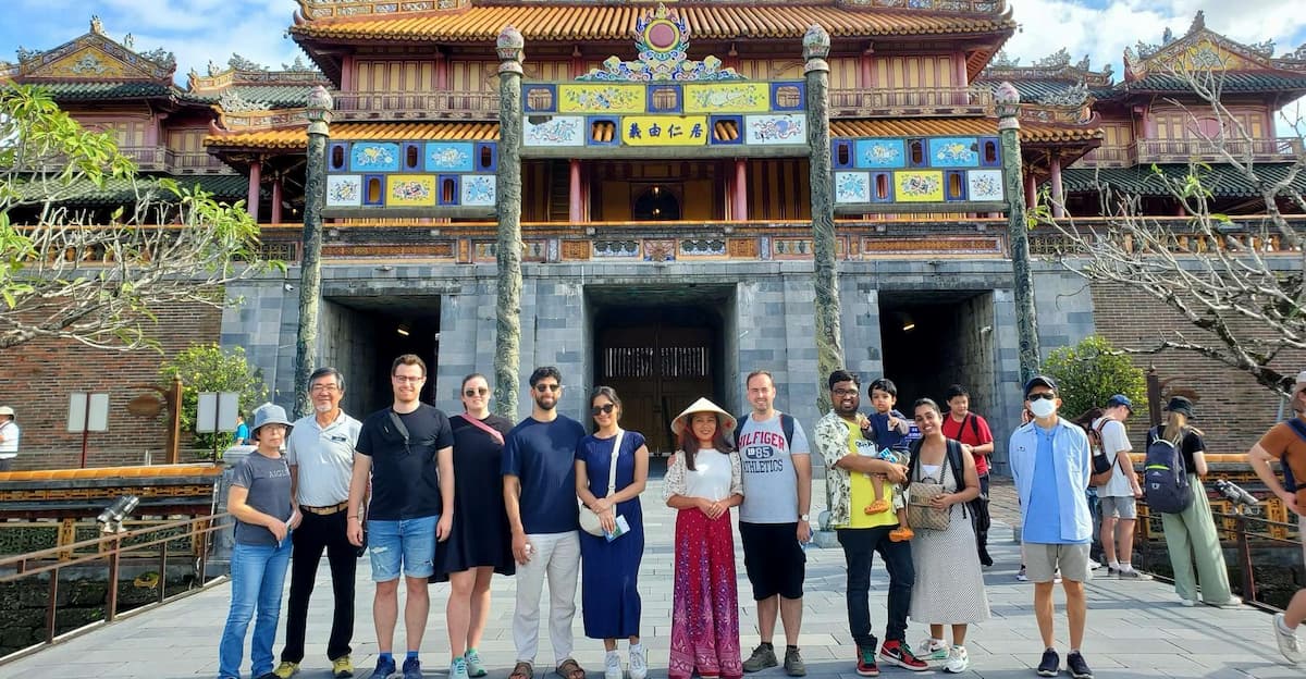 Туристы в закрытой одежде перед буддийской пагодой в Хойане