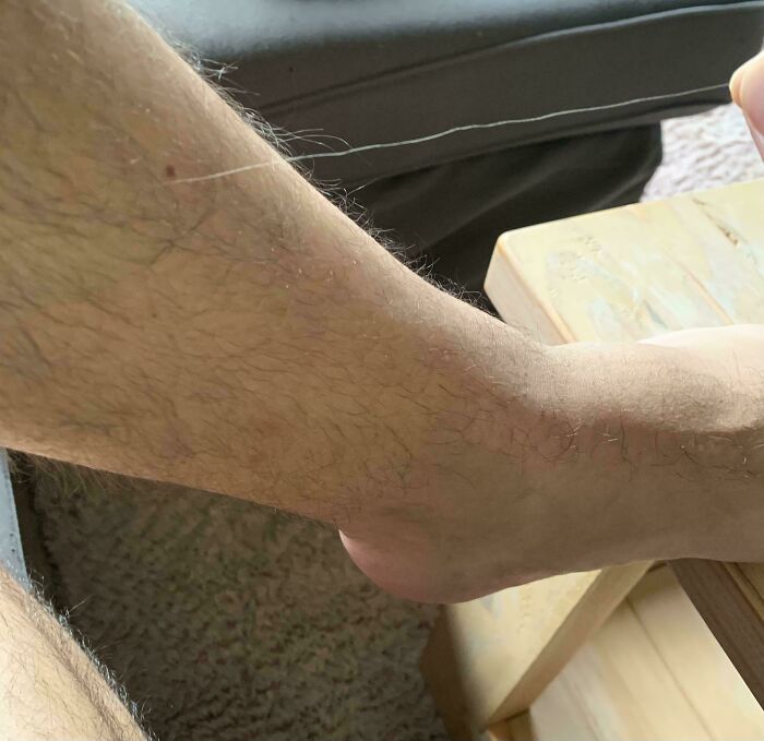 Волосатая мужская рука с длинным волосом на фоне ковра