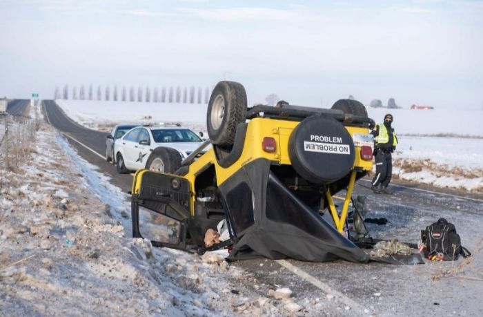 Jeep Wrangler желтого цвета, который перевернулся на крышу на заснеженной дороге