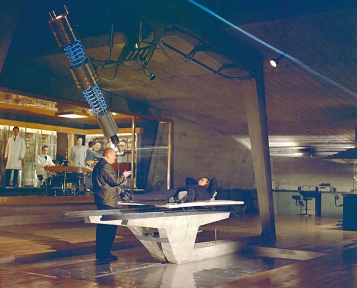 Мужчина режет стол ацетиленовой горелкой для съёмок сцены с лазером в Голдфингере 1964