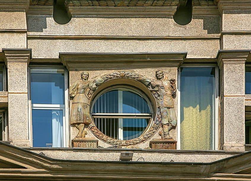 Окулусы главного фасада Минского ГУМа с фигурами крестьян в национальных белорусских костюмах