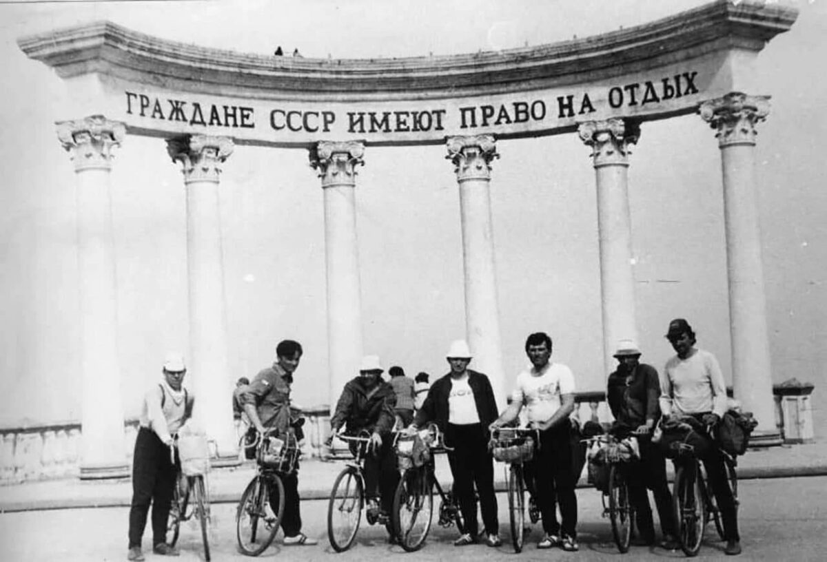 Группа велосипедистов на фоне арки с надписью: Граждане имеют право на отдых