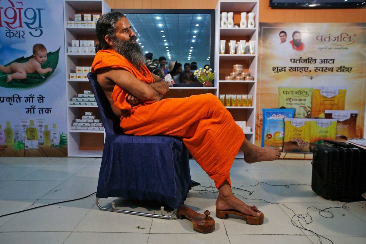 Баба Рамдев в магазине Patanjali рядом с продуктами Coronil и аюрведическими препаратами