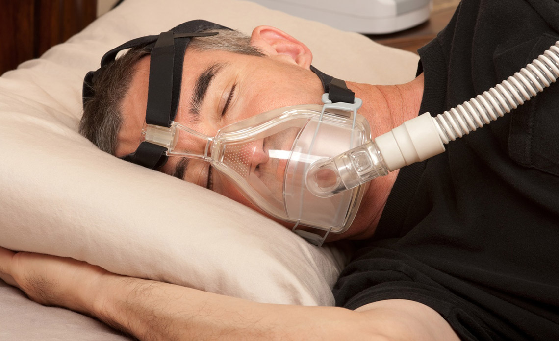 Человек с маской CPAP для лечения апноэ сна