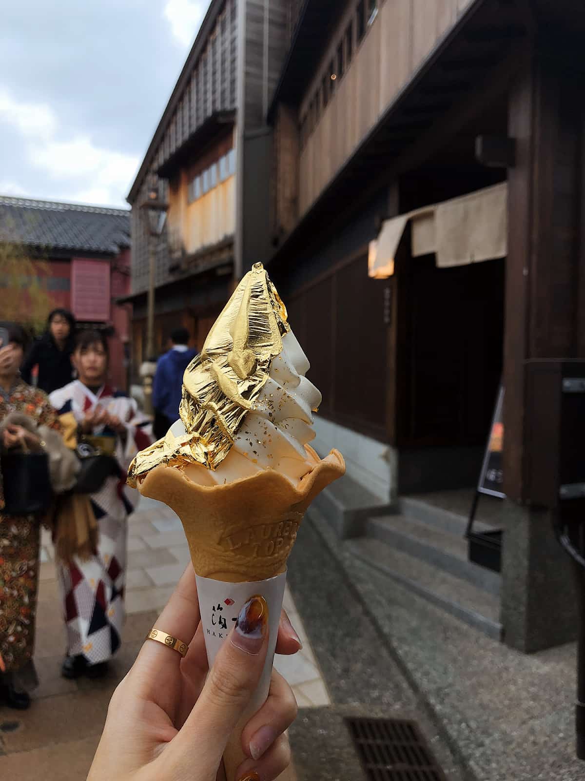 японское мороженое Kanazawa Ice в руке на фоне летней улицы