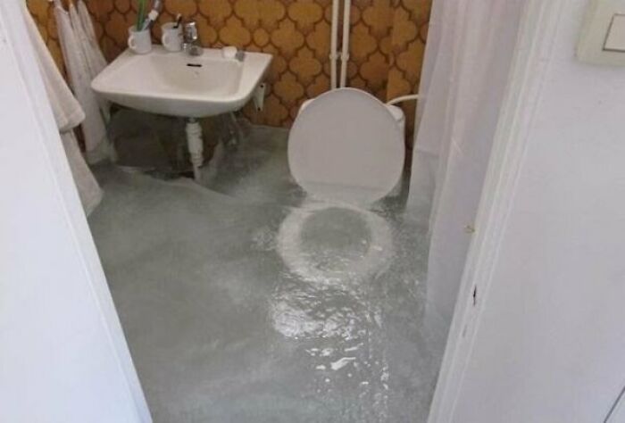 Ванная комната с водой на полу вокруг унитаза