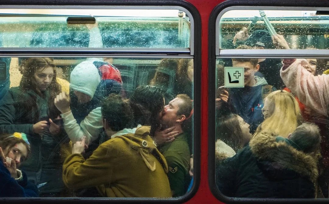 Толпа людей в переполненном вагоне поезда целуется у стекла