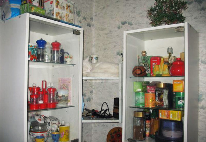 Белый кот спит на белой полке на кухне