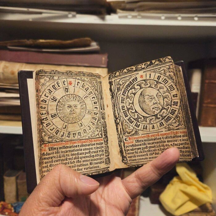 Старинная книга с солнцем и луной в руке