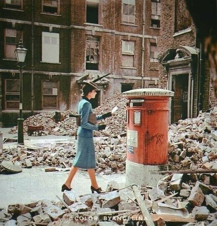 Женщина опускает письмо в почтовый ящик среди руин Лондона, 1940