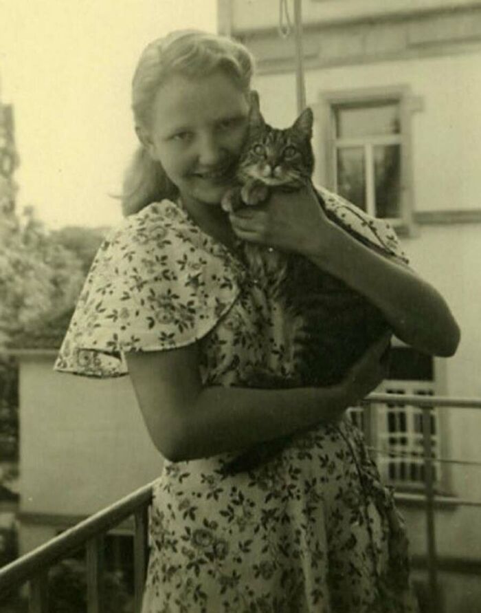 Молодая женщина обнимает полосатого кота на балконе, 1930-е годы
