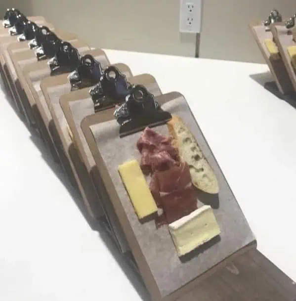 Мясная и сырная нарезка на офисных планшетах с металлическими зажимами