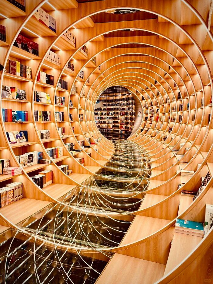 Деревянные круглые полки с книгами, образующие туннель
