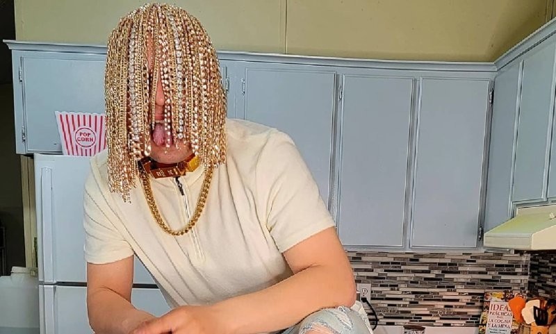 Человек на кухне, лицо которого закрыто золотыми косами