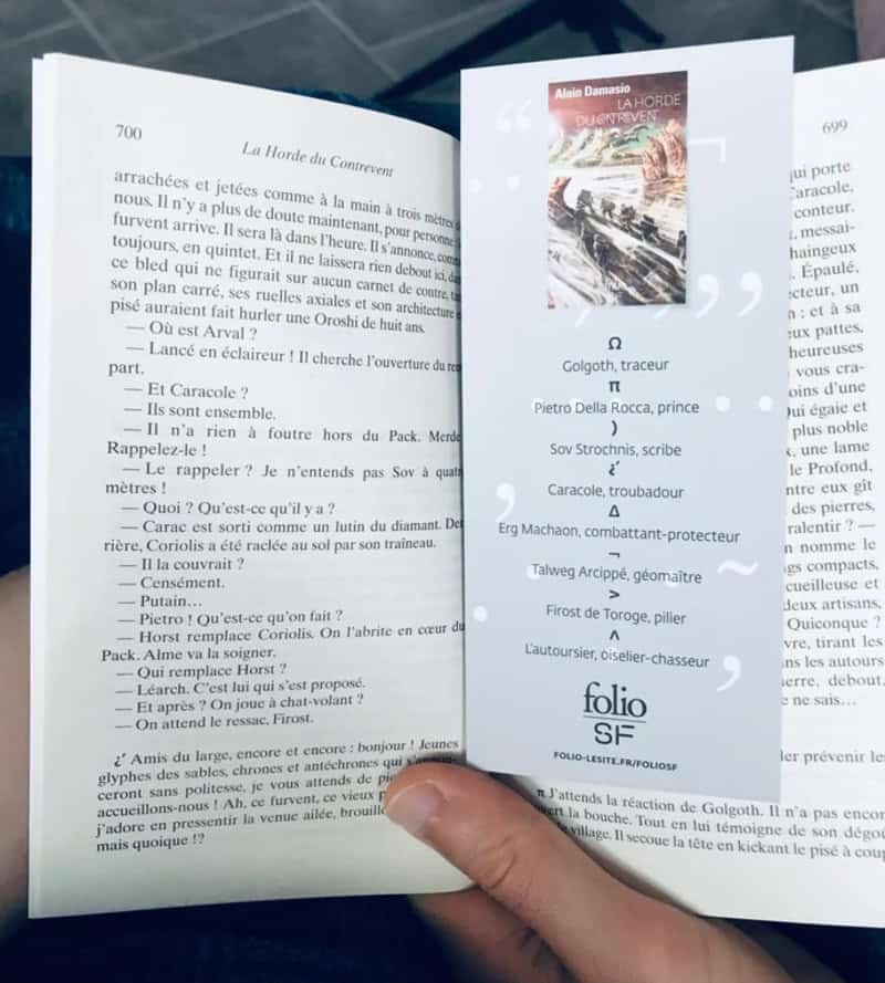 Открытая книга и закладка со списком имён персонажей в руке