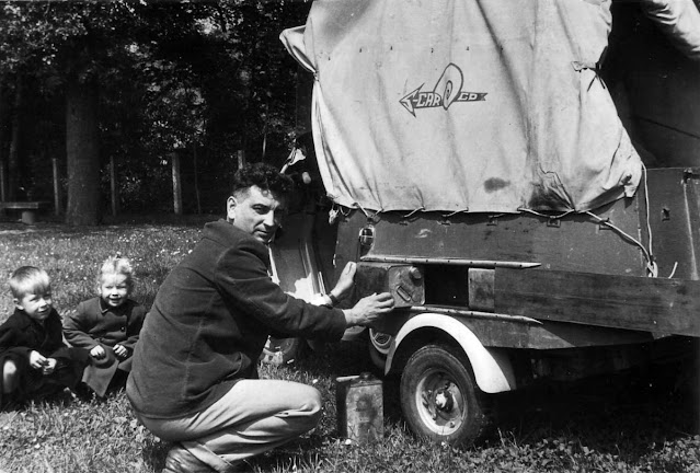 Ги Монтен ремонтирует будку, дети сидят рядом