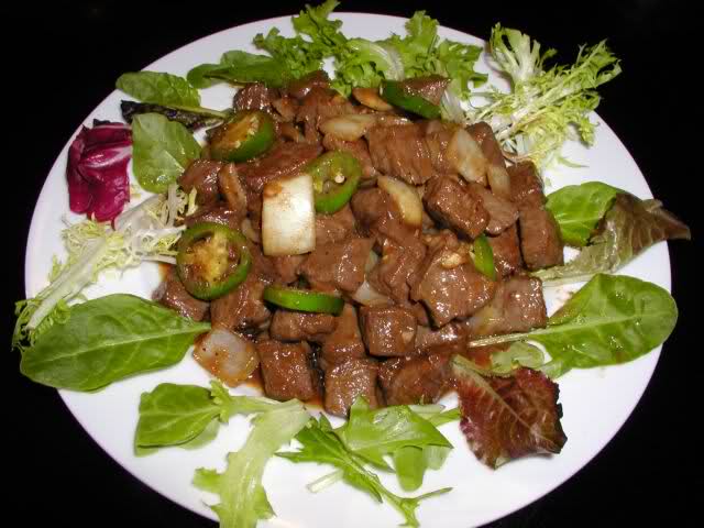 Жареное кошачье мясо с чесноком на столе ханойского ресторана