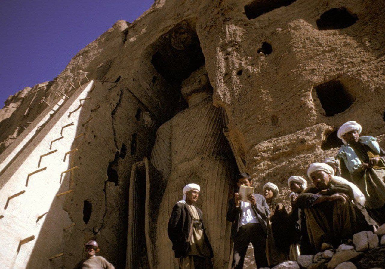 1999 год: боец Талибана с автоматом стоит на страже у подножия гигантской статуи Будды, которую позже уничтожат